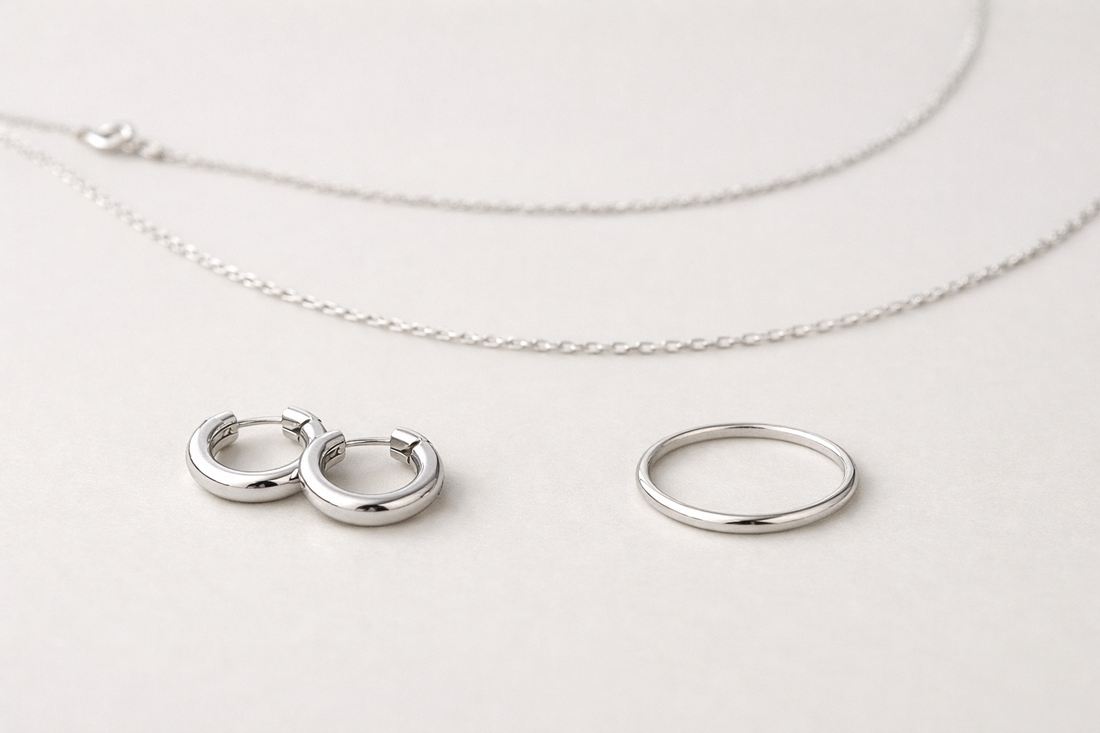 Assortiment kleine zilveren sieraden op een lichte neutrale achtergrond